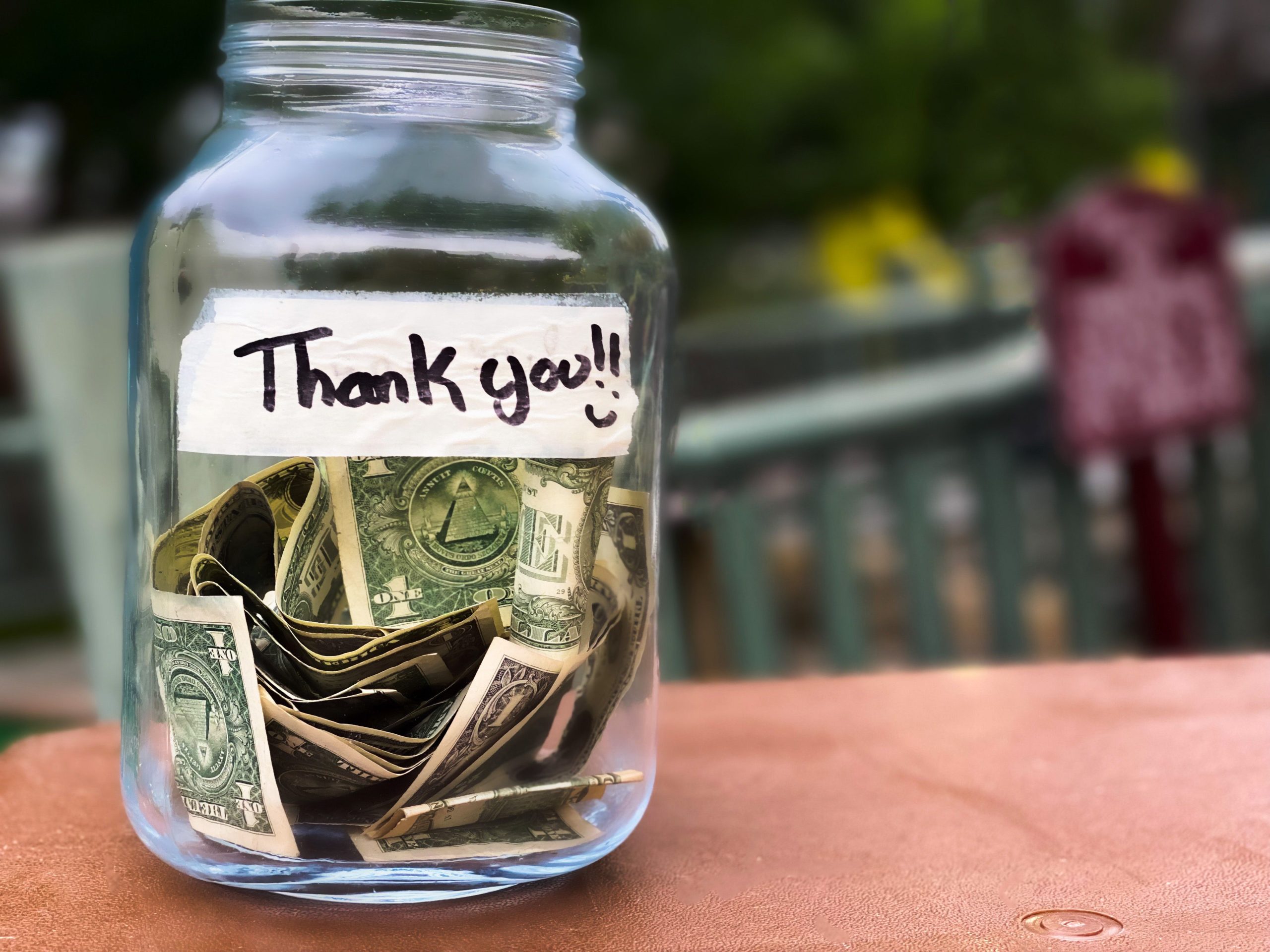 Tip jar with dollar bills in it