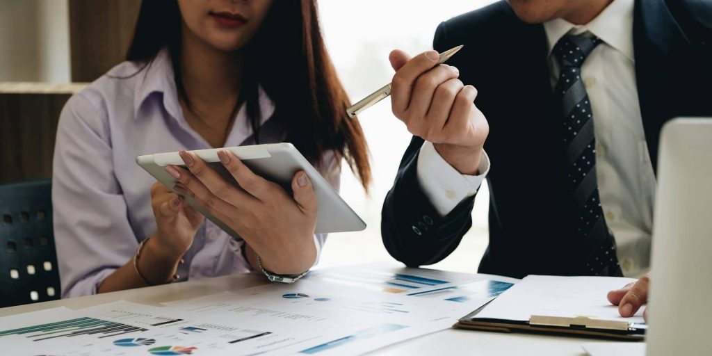 business owner and advisor reviewing documents and charts at a desk