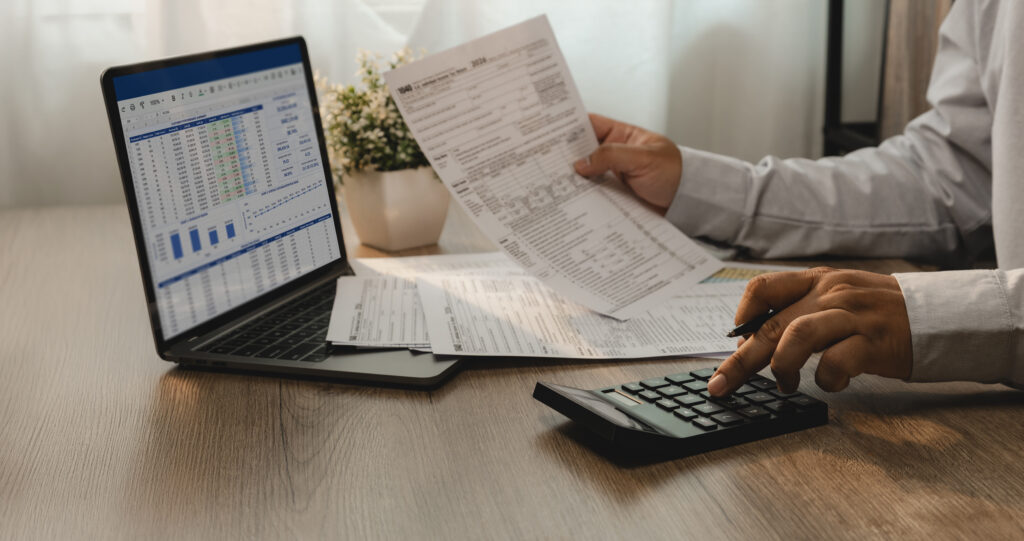 Person sitting at a table working on tax forms.